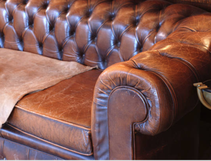 An old leather couch with cracked leather seats